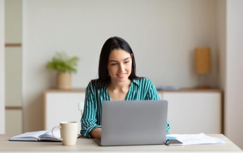 businesswoman-working-on-laptop-sitting-at-workplace-in-office.jpg